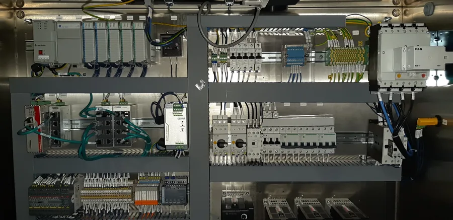 Interior de un tablero en acero inoxidable con PLC modular, switches de red industrial, protecciones y borneras cableadas